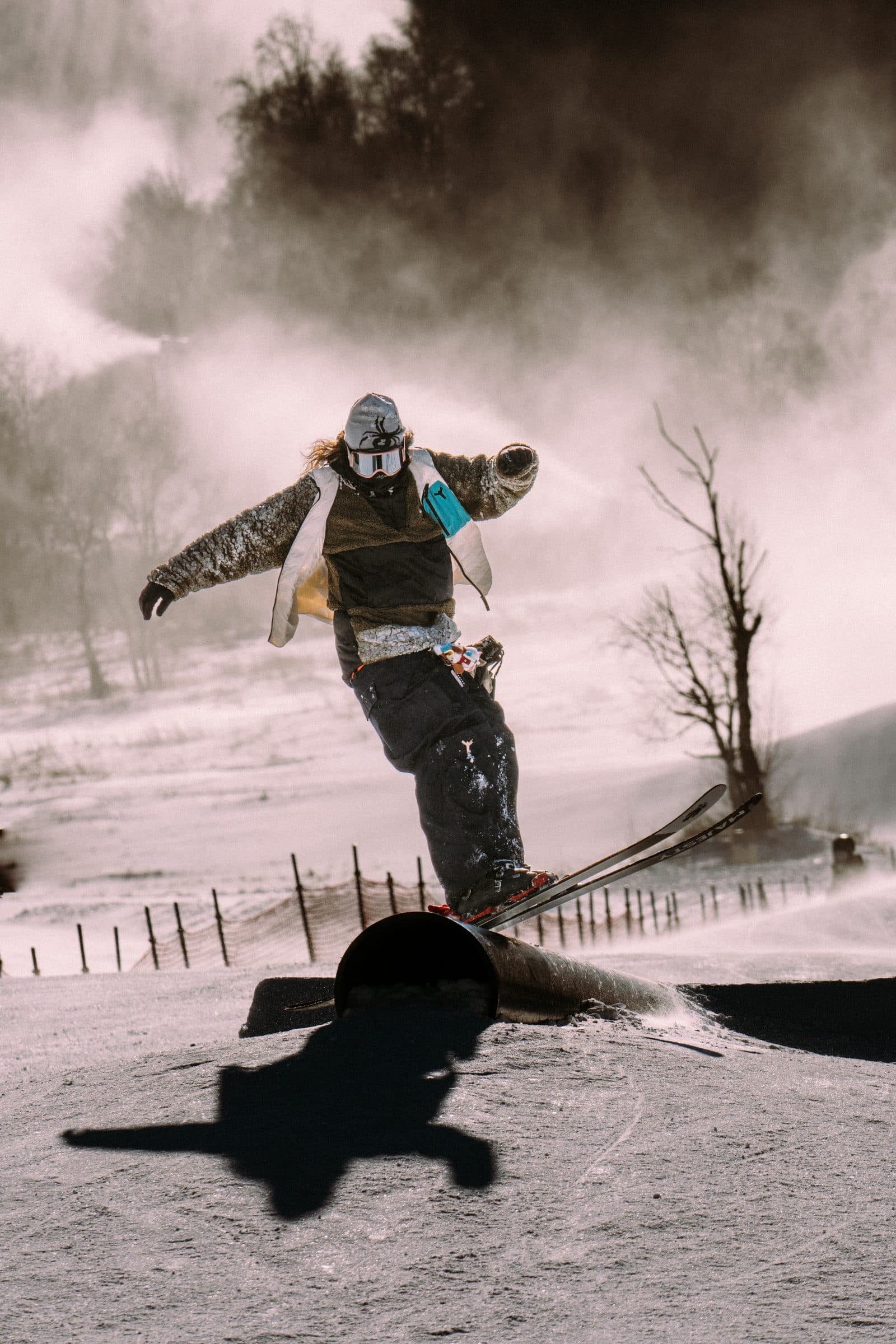 Freeskier sklir på en rail i snøparken på twintipski